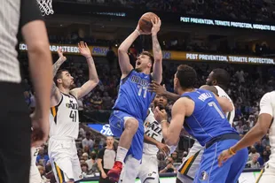 Slovenian Luka Doncic (77), of the Dallas Mavericks, looks for the basket in front of Spaniard Juancho Hernangomez (41), Donovan Mitchell (45) and other Utah Jazz defenders, in the second half of the game in Dallas.  , Sunday, March 27, 2022 (AP Photo/LM Otero)