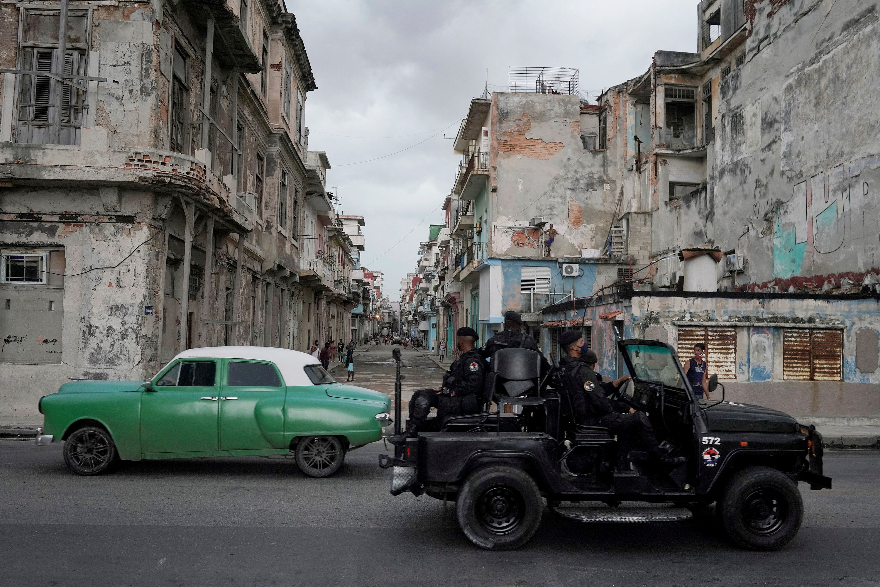 FILE PHOTO: A special forces vehicle drives past an old car in downtown Havana, Cuba on July 13, 2021. REUTERS/Alexandre Menegini/File Photo